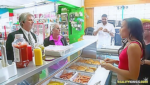 Asian teens in red and black dresses in hot dog stand